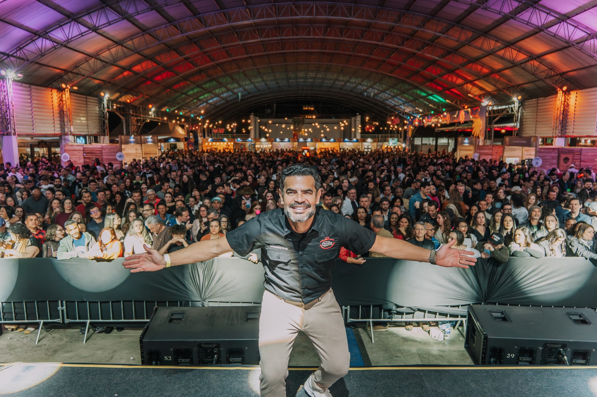 Alessandro Eller de braços abertos no palco, com o público do Festival Primavera Teresense 2026 ao fundo.