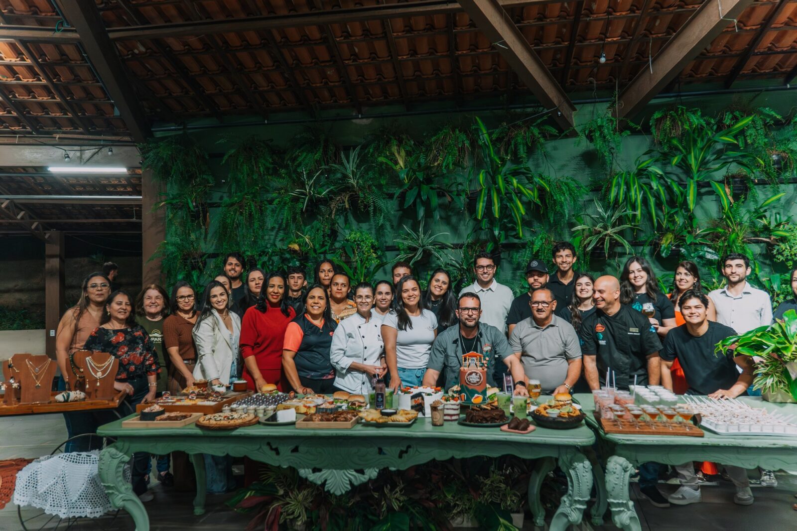 Grupo reunido atrás de uma mesa com os pratos apresentados para o Sabores do Caparaó em Irupi.